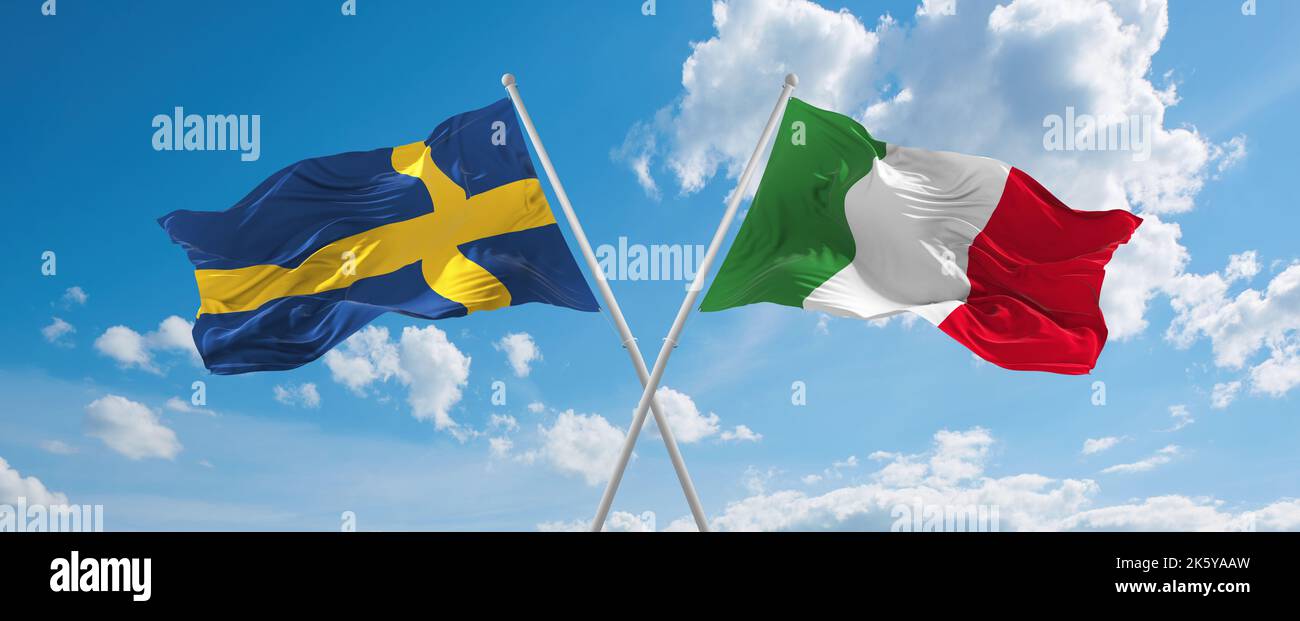 two crossed flags Italy and Sweden waving in wind at cloudy sky ...