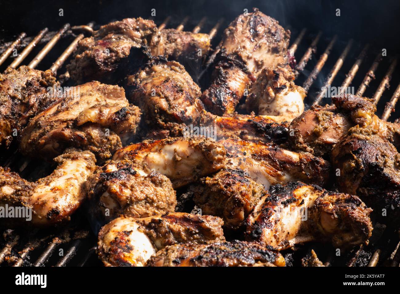 Grilling traditional Jamaican spicy jerk chicken with over charcoal fire Stock Photo Alamy