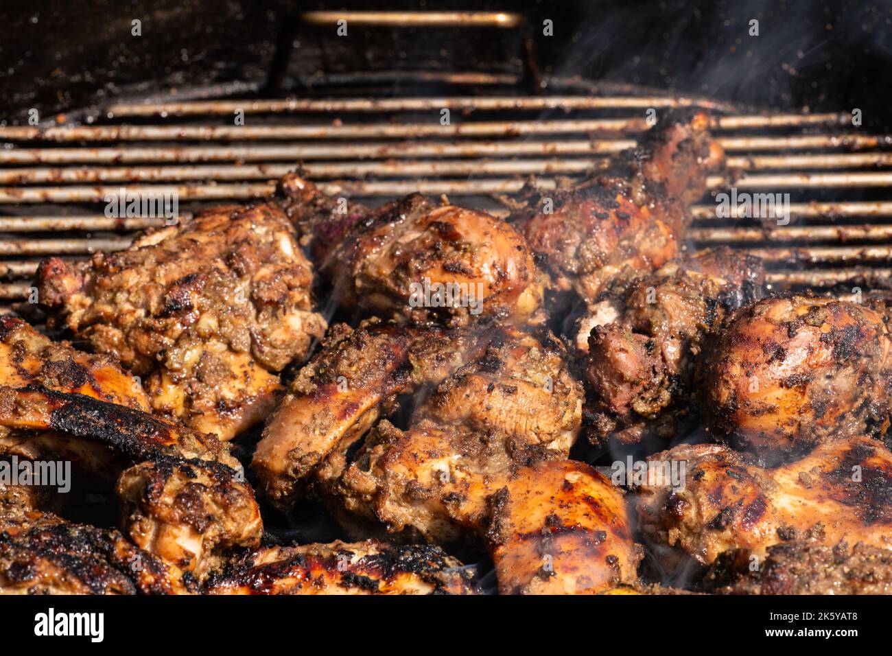 Grilling traditional Jamaican spicy jerk chicken with over charcoal fire Stock Photo Alamy