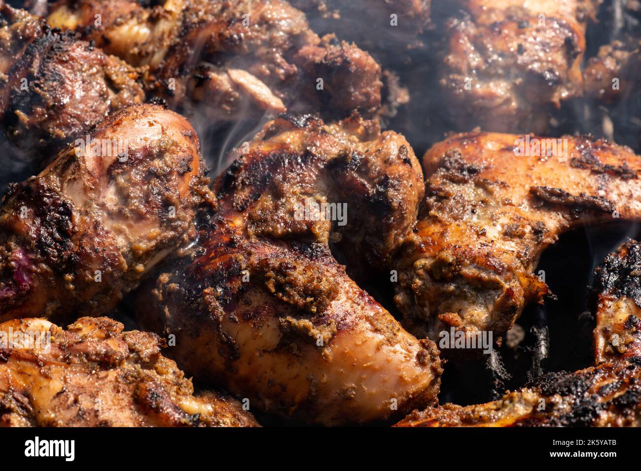 Grilling traditional Jamaican spicy jerk chicken with over charcoal fire Stock Photo Alamy