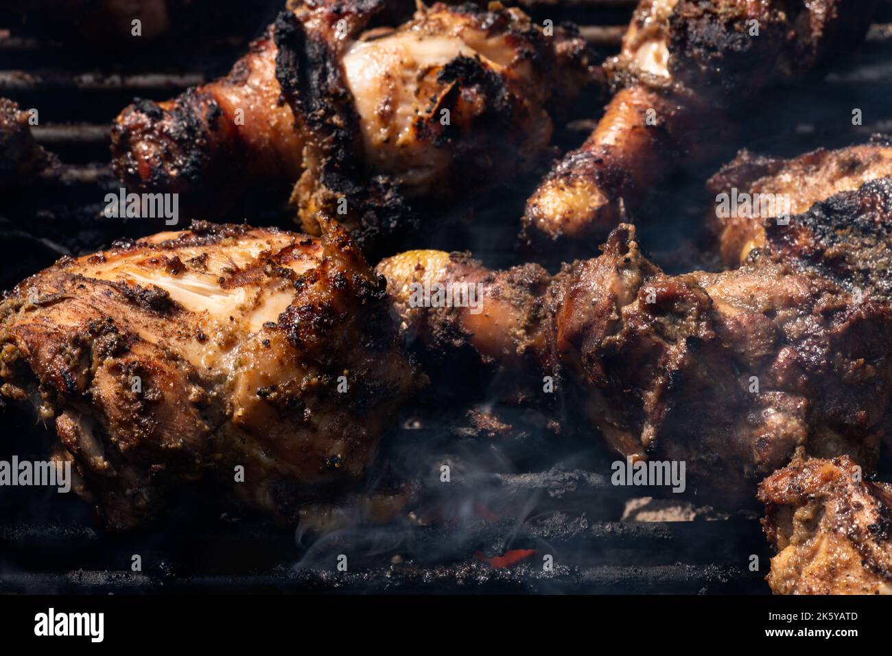 Grilling traditional Jamaican spicy jerk chicken with over charcoal fire Stock Photo Alamy