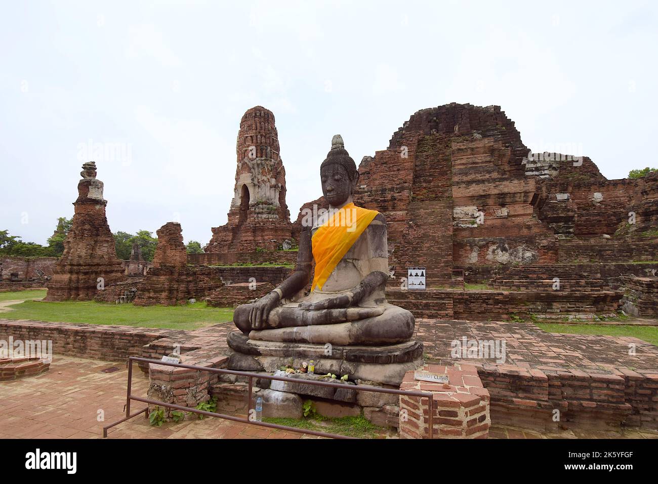 Partially restored Buddha image in earth touching pose, seated in front of ruins of central prang, Wat Mahathat, Ayutthaya Historical Park Stock Photo