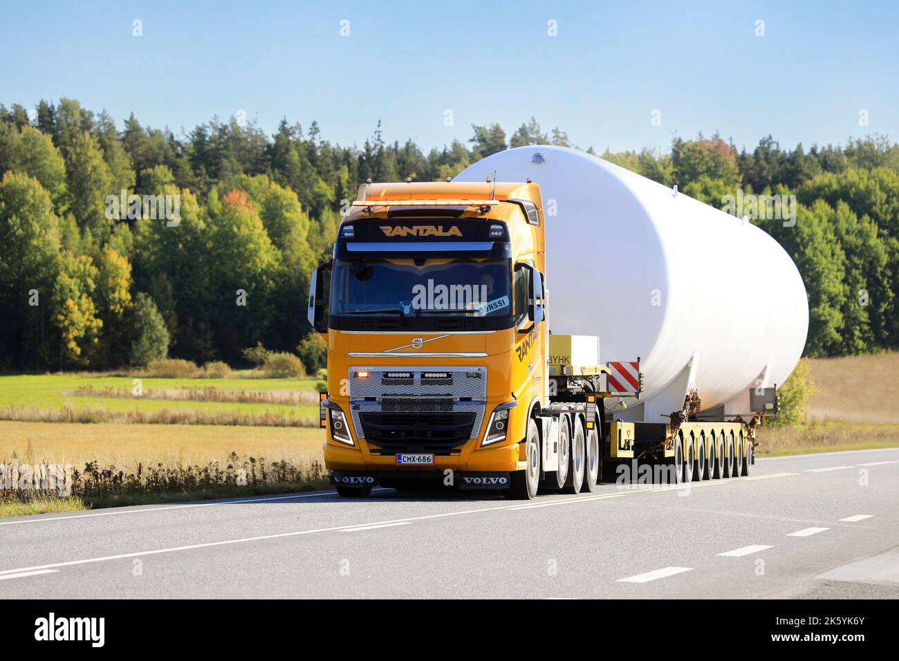 Wide load transport of LNG storange tank by yellow Volvo FH16 semi trailer truck of Rantala on road. Oversize load. Salo, Finland. September 22, 2022. Stock Photo