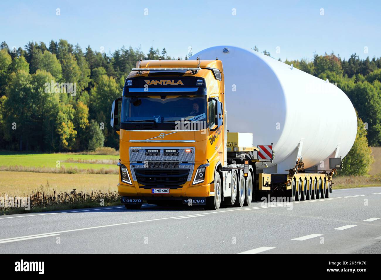 Wide load transport of LNG storange tank by yellow Volvo FH16 semi trailer truck of Rantala on road. Oversize load. Salo, Finland. September 22, 2022. Stock Photo