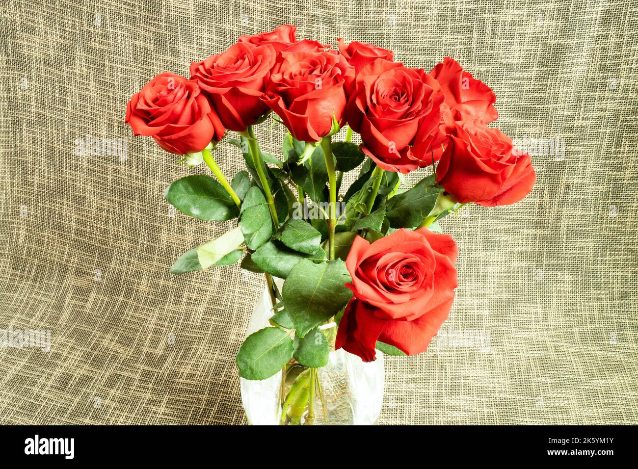 Bouquet of roses in glass vase and textile background Stock Photo - Alamy
