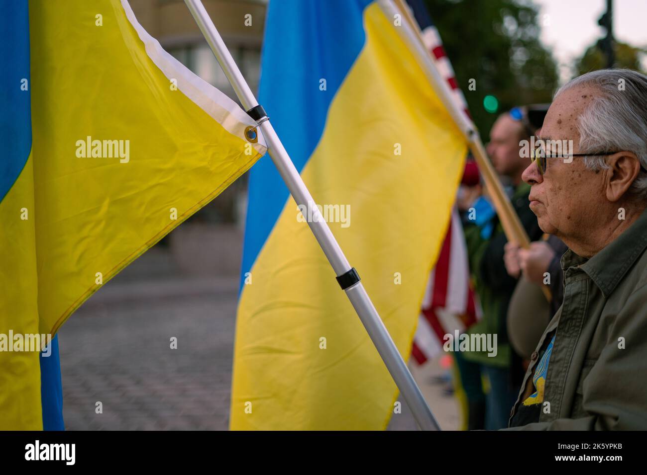 A man holds the Ukrainian in front of the Russian Embassy. Demonstrators gathered in front of the Embassy of the Russian Federation to protest against the recent war crimes committed in Ukraine. The protesters sang traditional Ukrainian songs and yelled at staff workers entering and exiting the embassy. (Photo by Jordan Tovin / SOPA Images/Sipa USA) Stock Photo