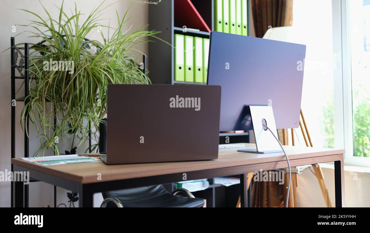Comfortable office interior with modern laptop and pc Stock Photo