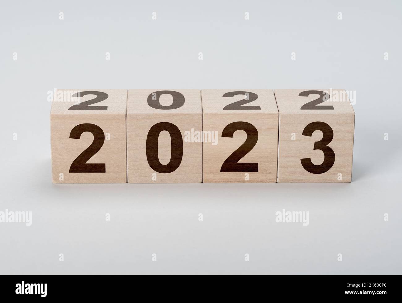 Wooden Blocks With 2022 2023 Number On gray background. new year concept. Wooden cube with flip over block 2022 to 2023 word. Business management, Ins Stock Photo
