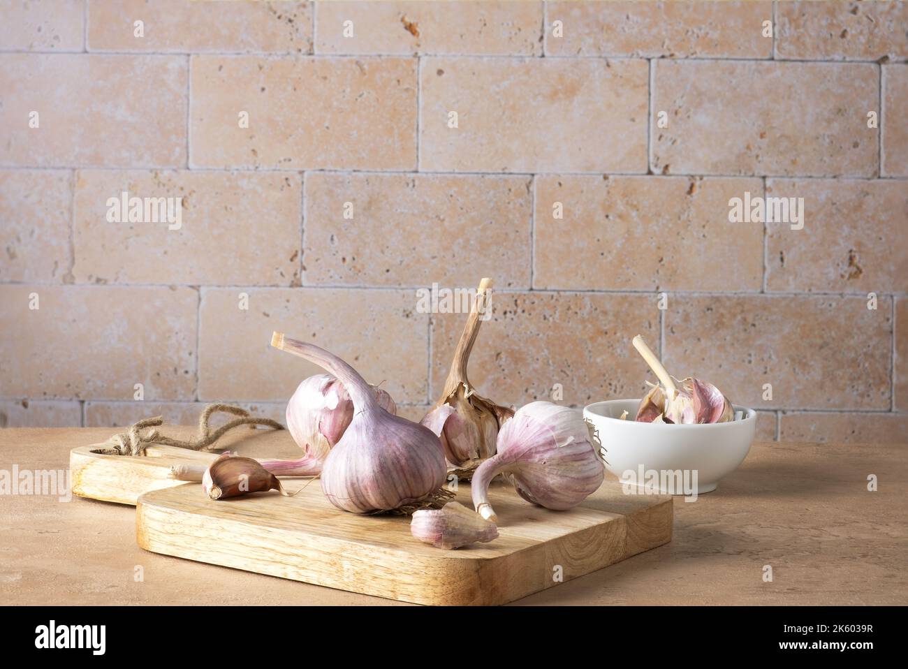 Heads and cloves of garlic lie on a cutting board. Stock Photo