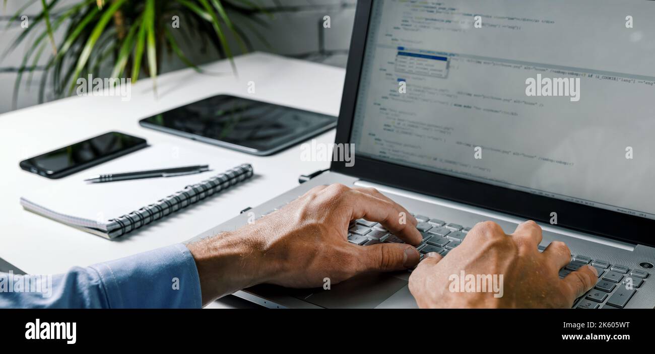 coder web developer write code on laptop computer. website programming, software development Stock Photo