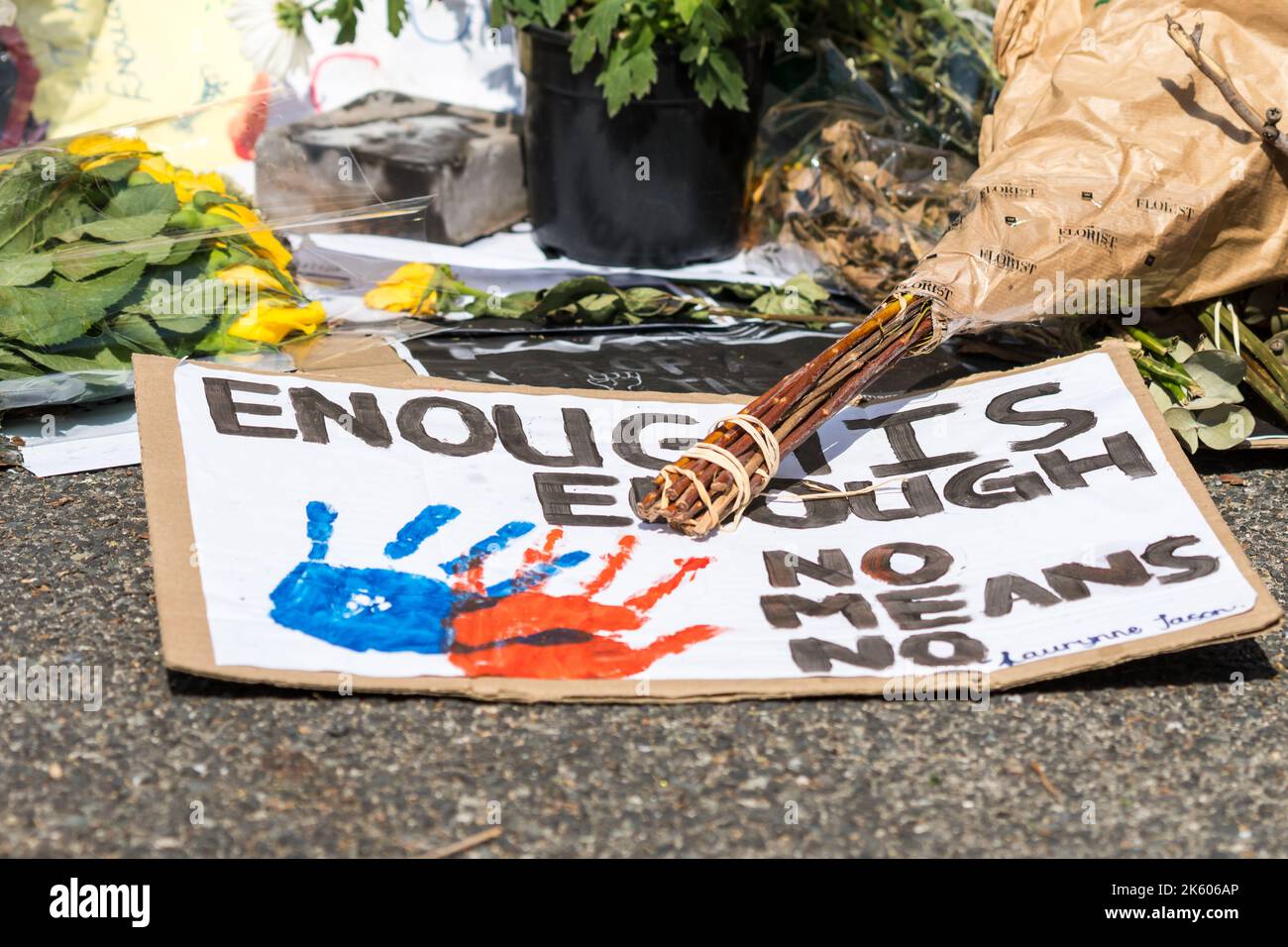 enough is enough hand written sign, poster, placard lying on a pavement ...