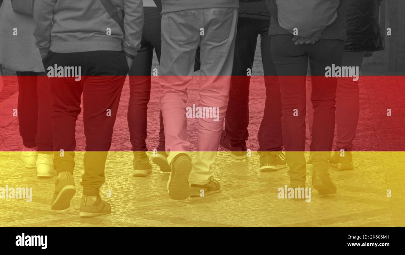 German society - people walking in the city and Germany flag Stock Photo