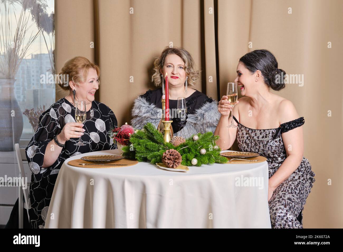 Three joyful middle age women celebrating christmas Stock Photo