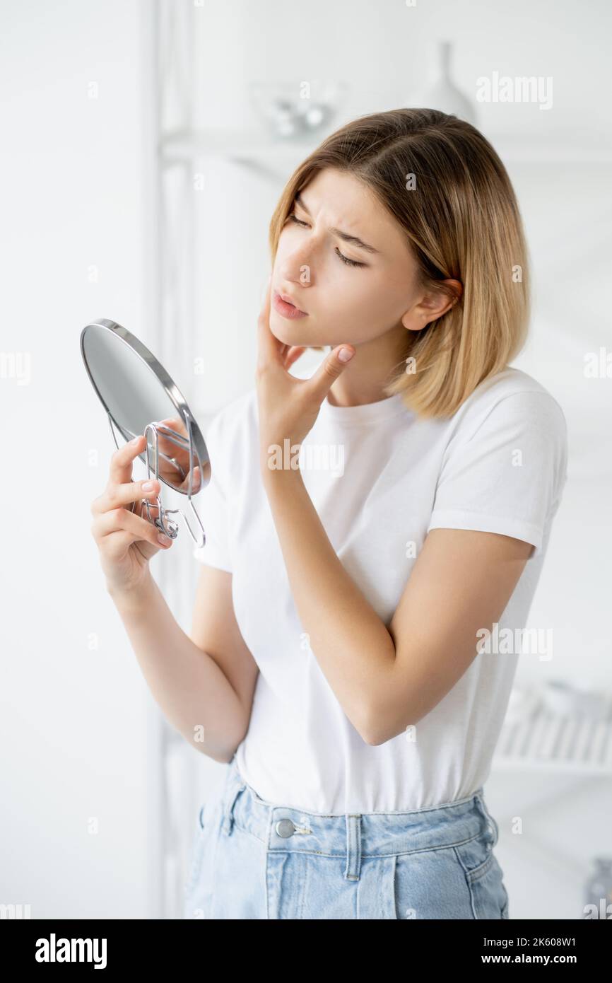 sensitive skin acne problem woman face mirror Stock Photo
