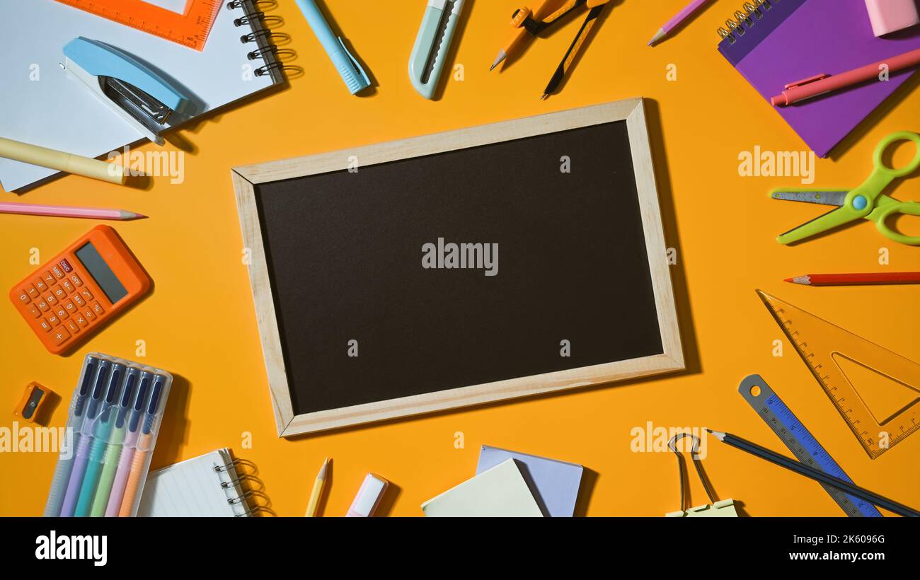 Top view empty blackboard surrounded by various school supplies on ...