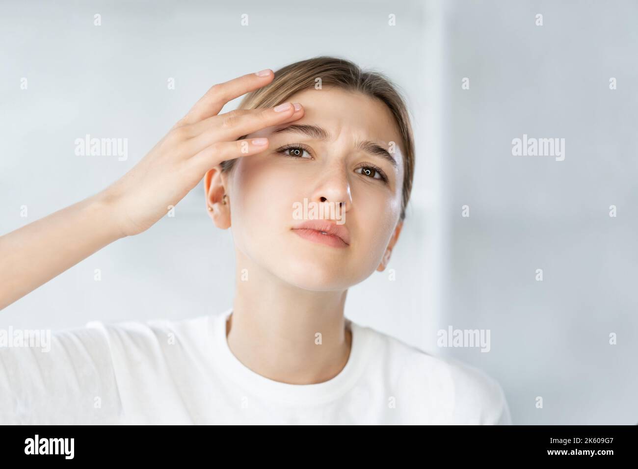 sensitive skin acne problem woman touching face Stock Photo