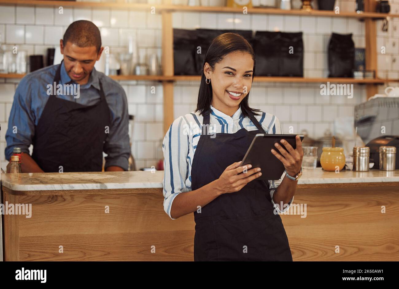 Portrait of a businesswoman ordering stock on her digital tablet. Business partners working together in restaurant kitchen. Entrepreneur using a Stock Photo