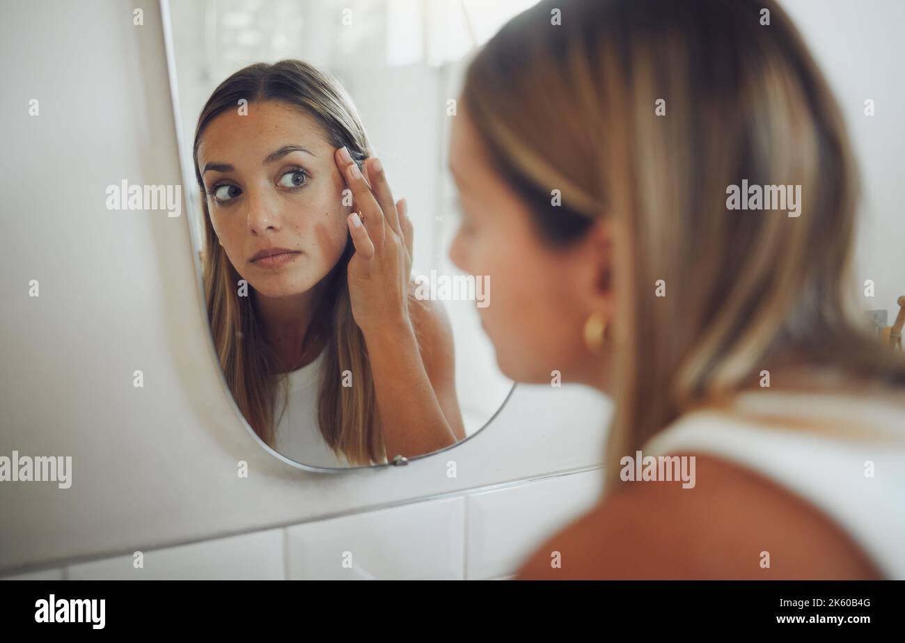 Close up of beautiful young caucasian woman looking in the mirror while