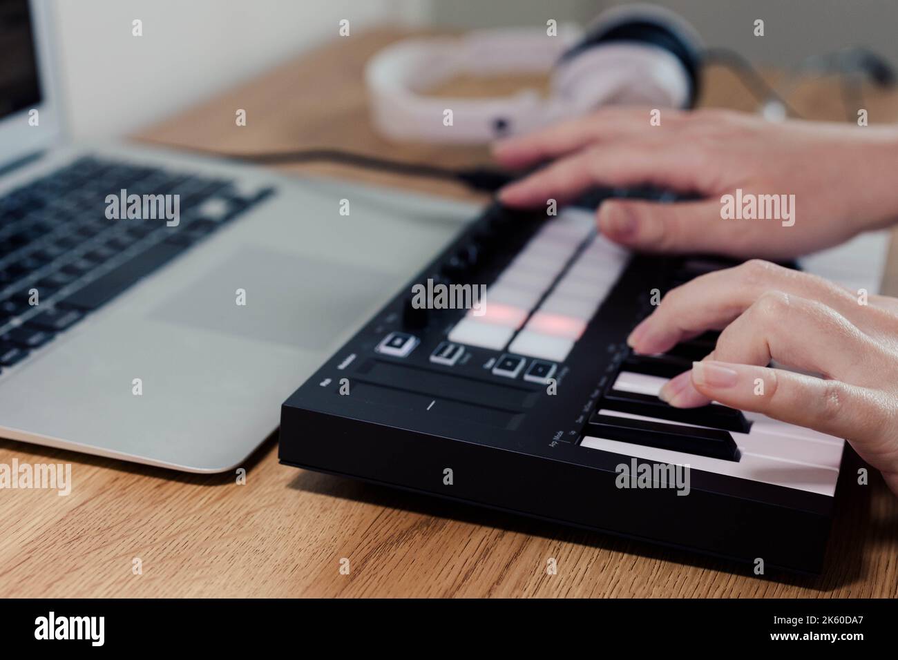 Midi Keyboard musician playing midi keyboard for arranging music on laptop computer Music production technology concept Stock Photo