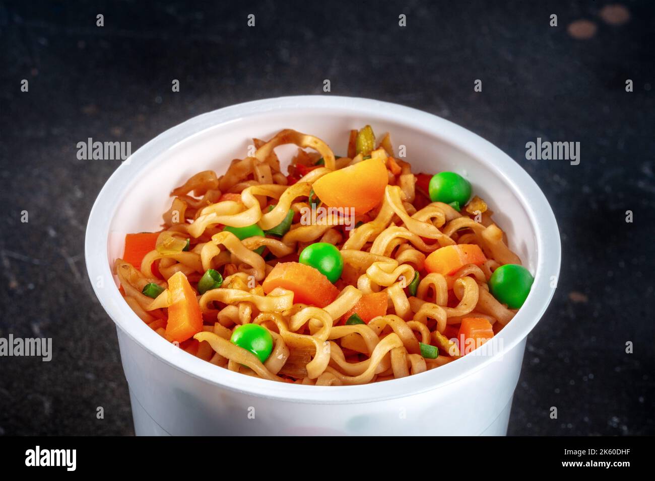 Ramen cup, instant soba noodles in a plastic cup with vegetables, green
