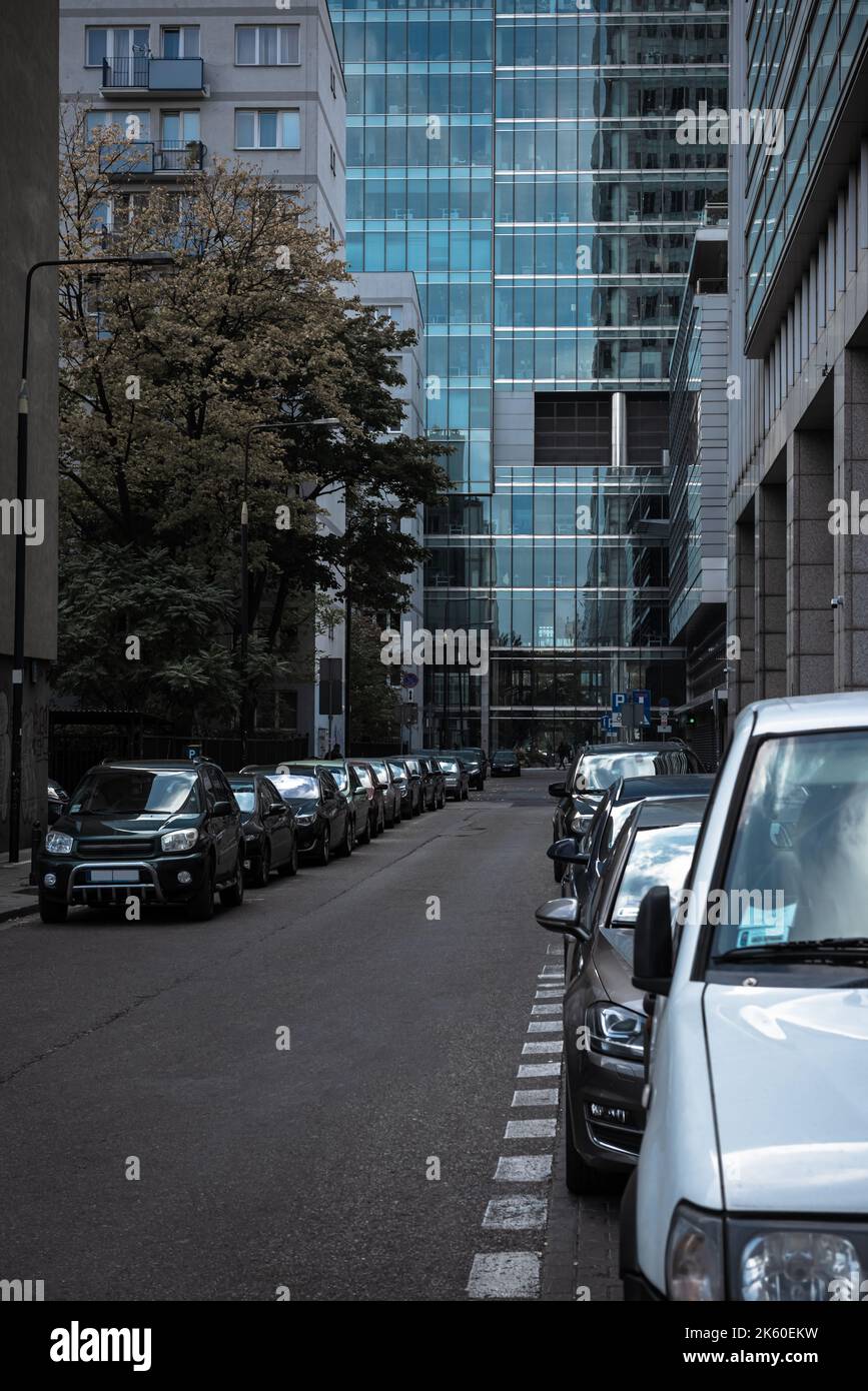 Parked cars on both sides of the road against the background of a glass ...