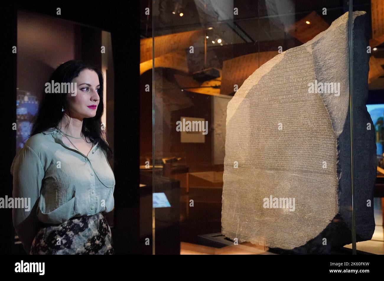 A member of staff observes the Rosetta Stone on display during the ...