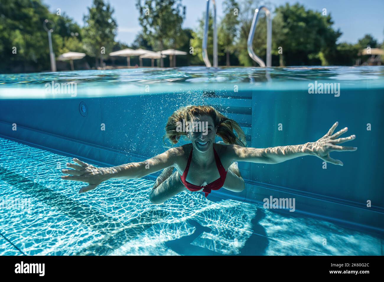 Pool Splits Open Split above and underwater photo of a woman swimming in pool during ...