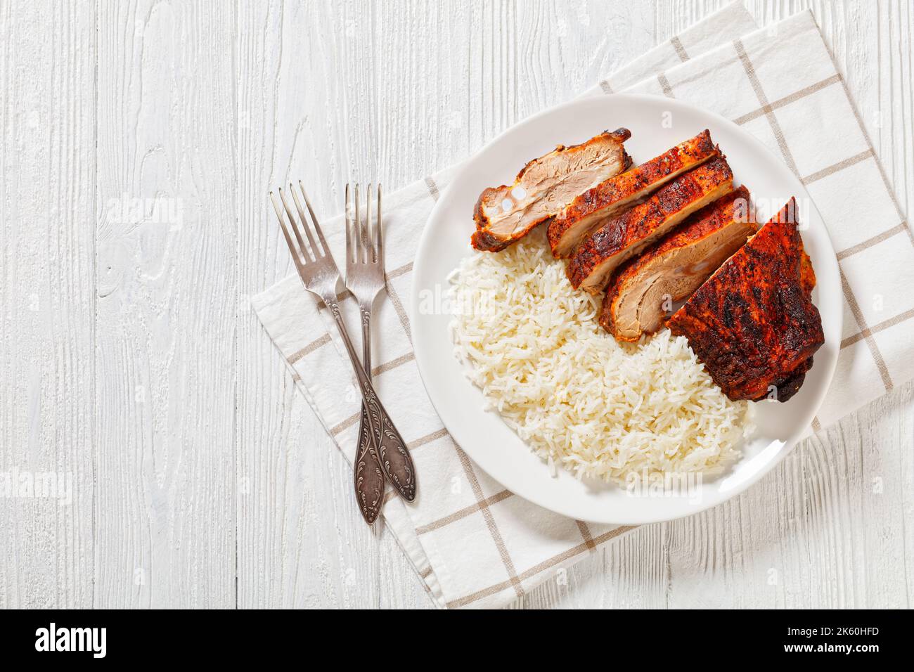 roast baby back pork meaty ribs with basmati rice on plate on white ...