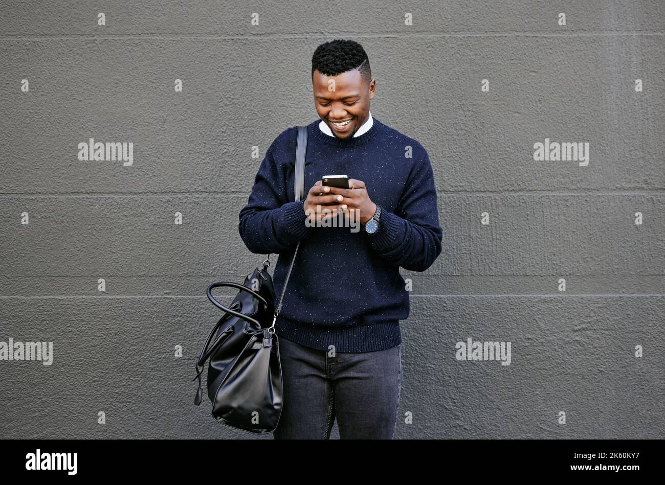 Businessman using his cellphone while walking in the city. Man using cellphone while commuting to work. Using internet while walking outside. Man Stock Photo