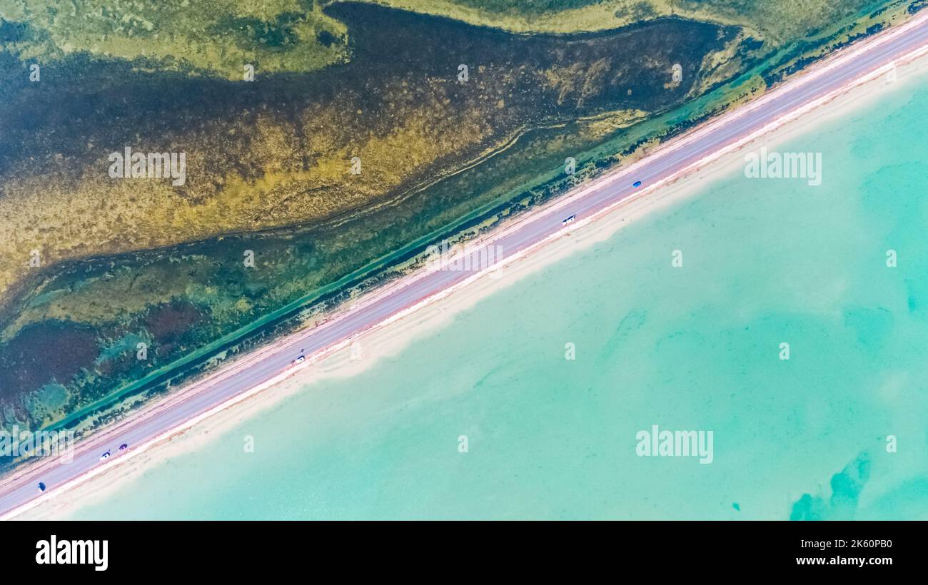 A drone view of a highway across Xitai Jinai Salt Lake and a green ...