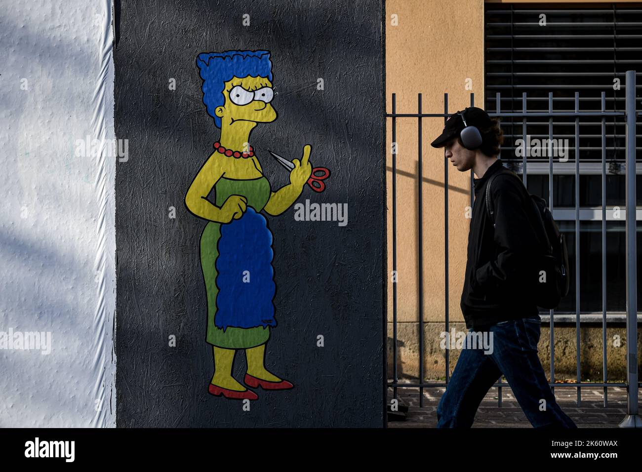 Milan, Italy on October 11, 2022, A man walks past a mural entitled ‘The Cut 2’ by street artist aleXsandro Palombo depicting The Simpsons' character Marge Simpson cutting her hair and giving the middle finger in solidarity with the women of Iran in front of the Iranian Consulate in Milan, Italy on October 11, 2022. A first version of a similar mural, entitled 'The Cut' appeared on October 5 at the same location and was later on removed. Credit: Piero Cruciatti/Alamy Live News Credit: Piero Cruciatti/Alamy Live News Stock Photo
