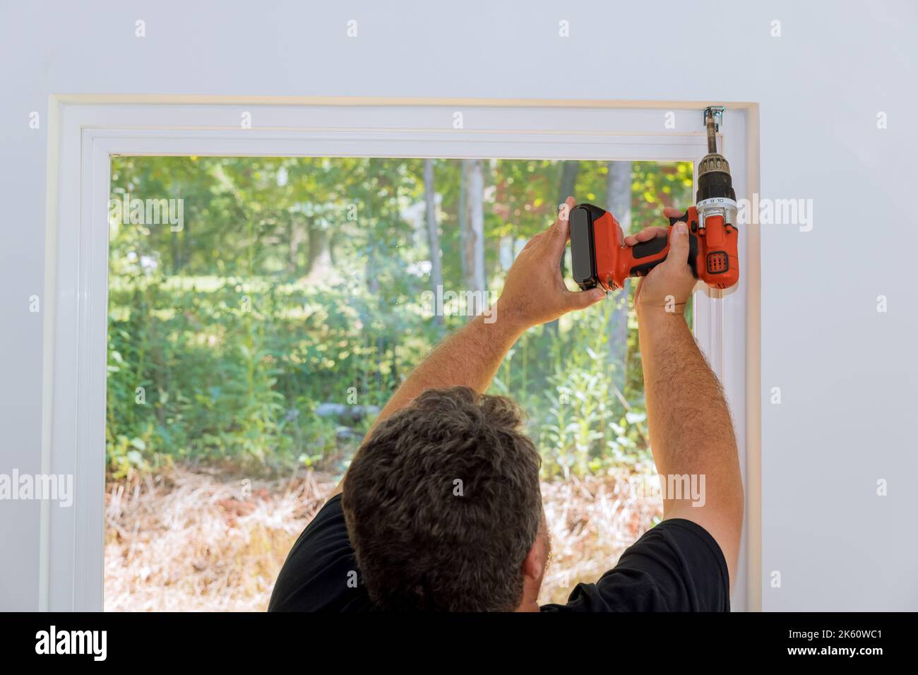 Professional technician is screwing the fastening to install blinds on windows of newly