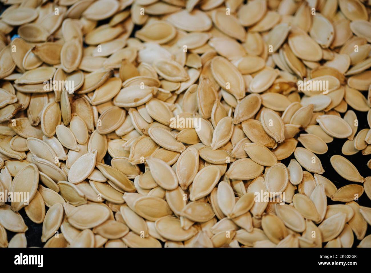 Scattered across the baking sheet roasted pumpkin seeds in shell Stock Photo