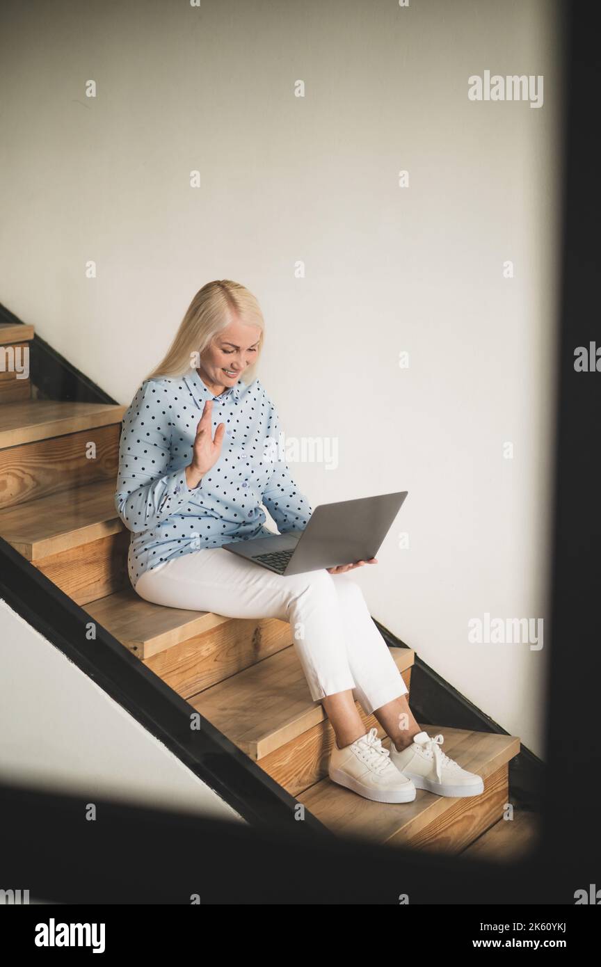 Joyous woman communicating with someone via Skype Stock Photo