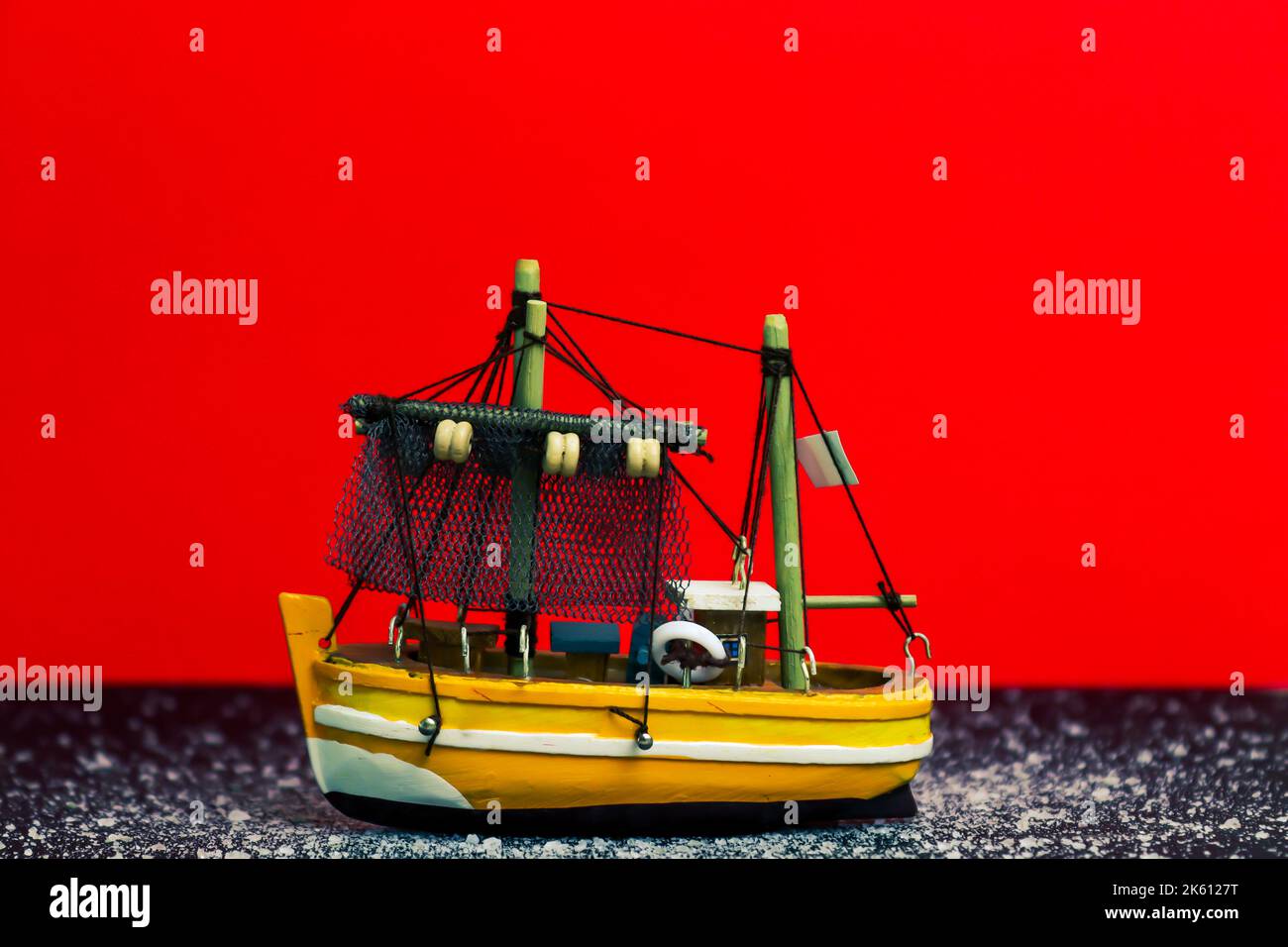 https://c8.alamy.com/comp/2K6127T/ship-toy-on-a-red-background-with-some-specific-elements-2K6127T.jpg