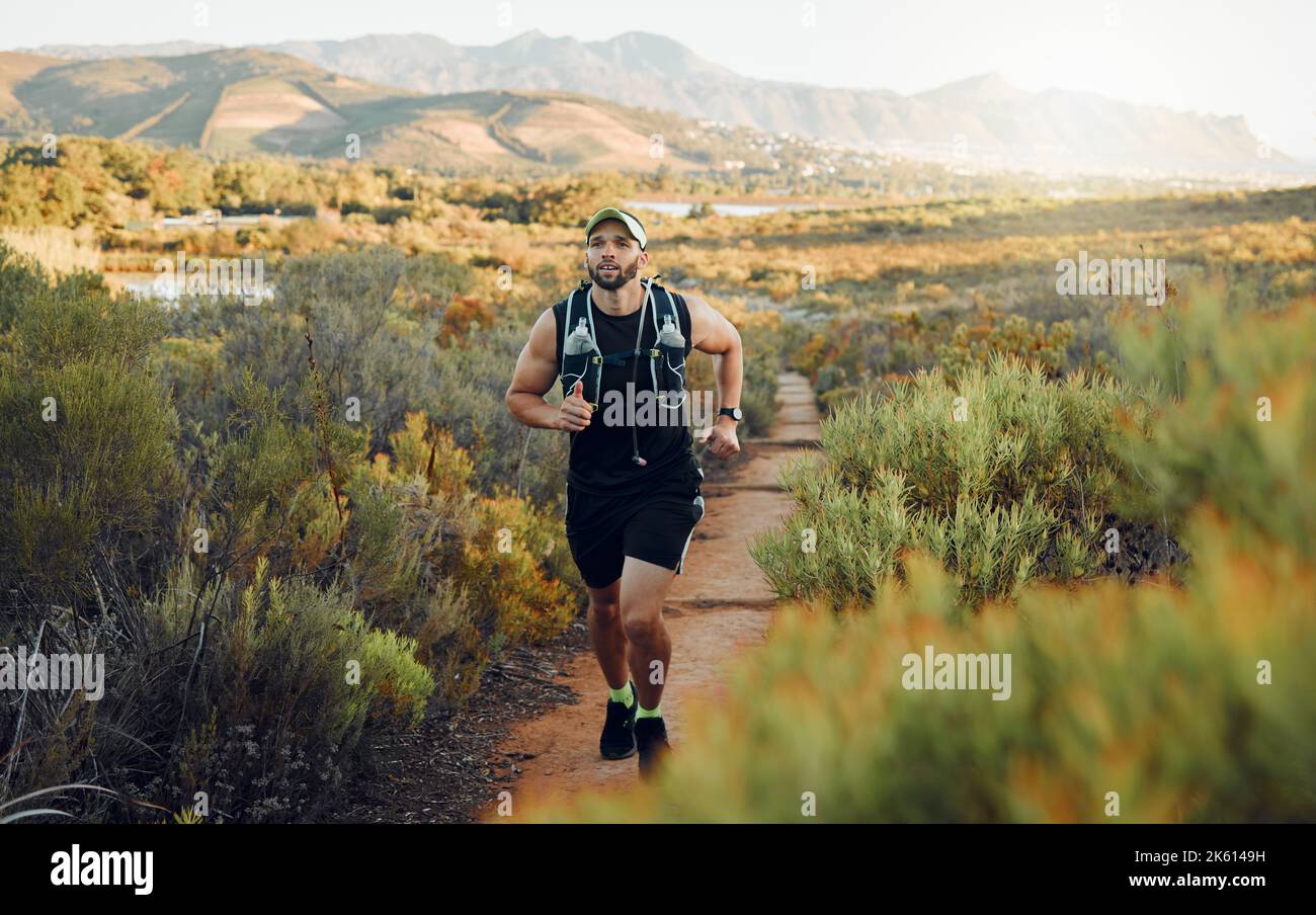 Runner, fitness or nature workout on mountains path, countryside landscape or sustainability environment. Sports man, athlete or running for health Stock Photo
