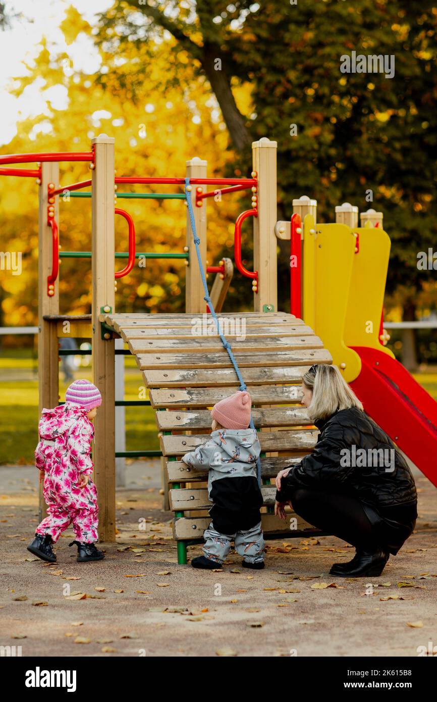 Toddlers playing in playground at park Stock Photo
