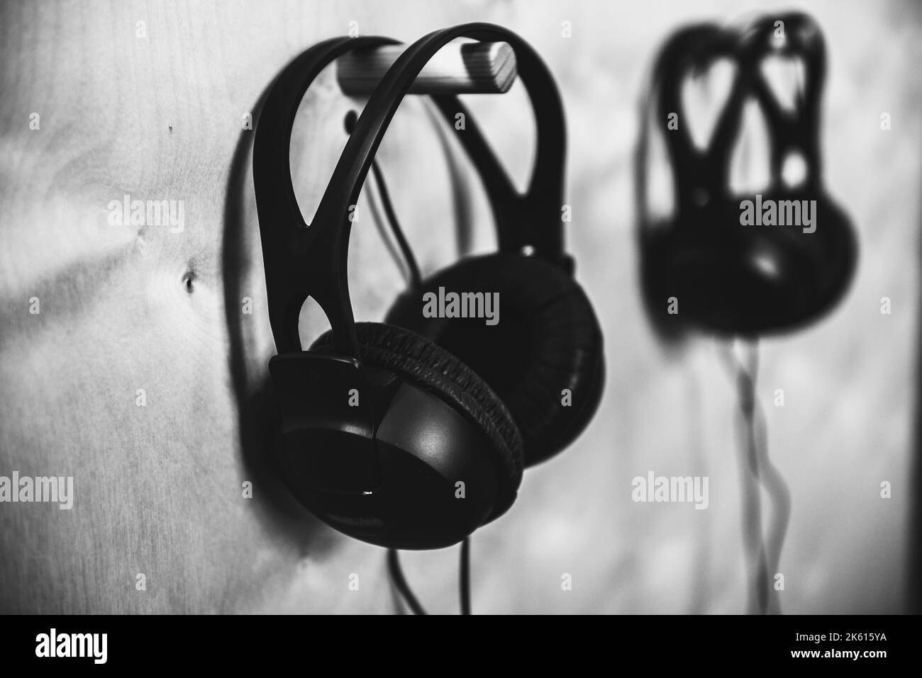 Headphones are hanging on the wall in a music studio. Black and white photography. Stock Photo
