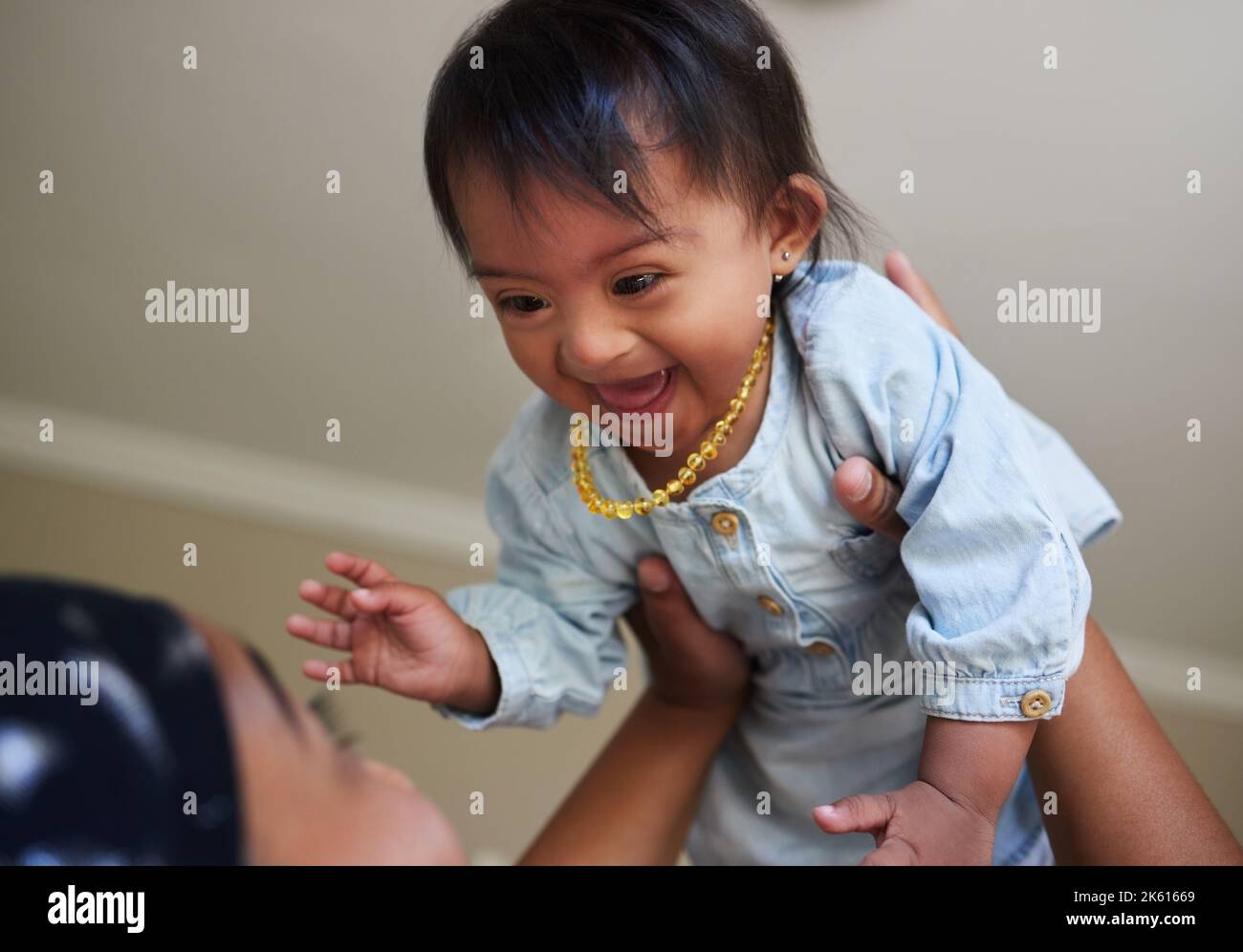 Children, down syndrome and fun with a girl and mother playing together in their home. Family, kids and disability with an adorable or cute daughter Stock Photo