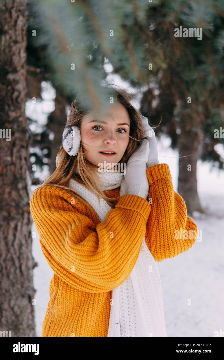 Teen blonde in a yellow sweater outside in winter. A teenage girl on a walk in winter clothes in