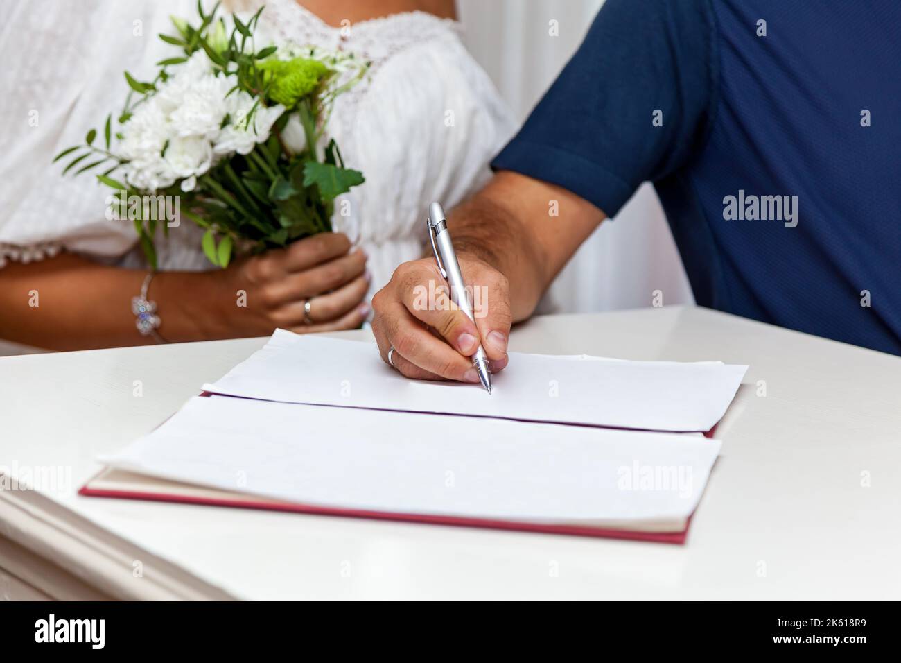 Wedding ceremony in the registry office, the bride and groom sign a