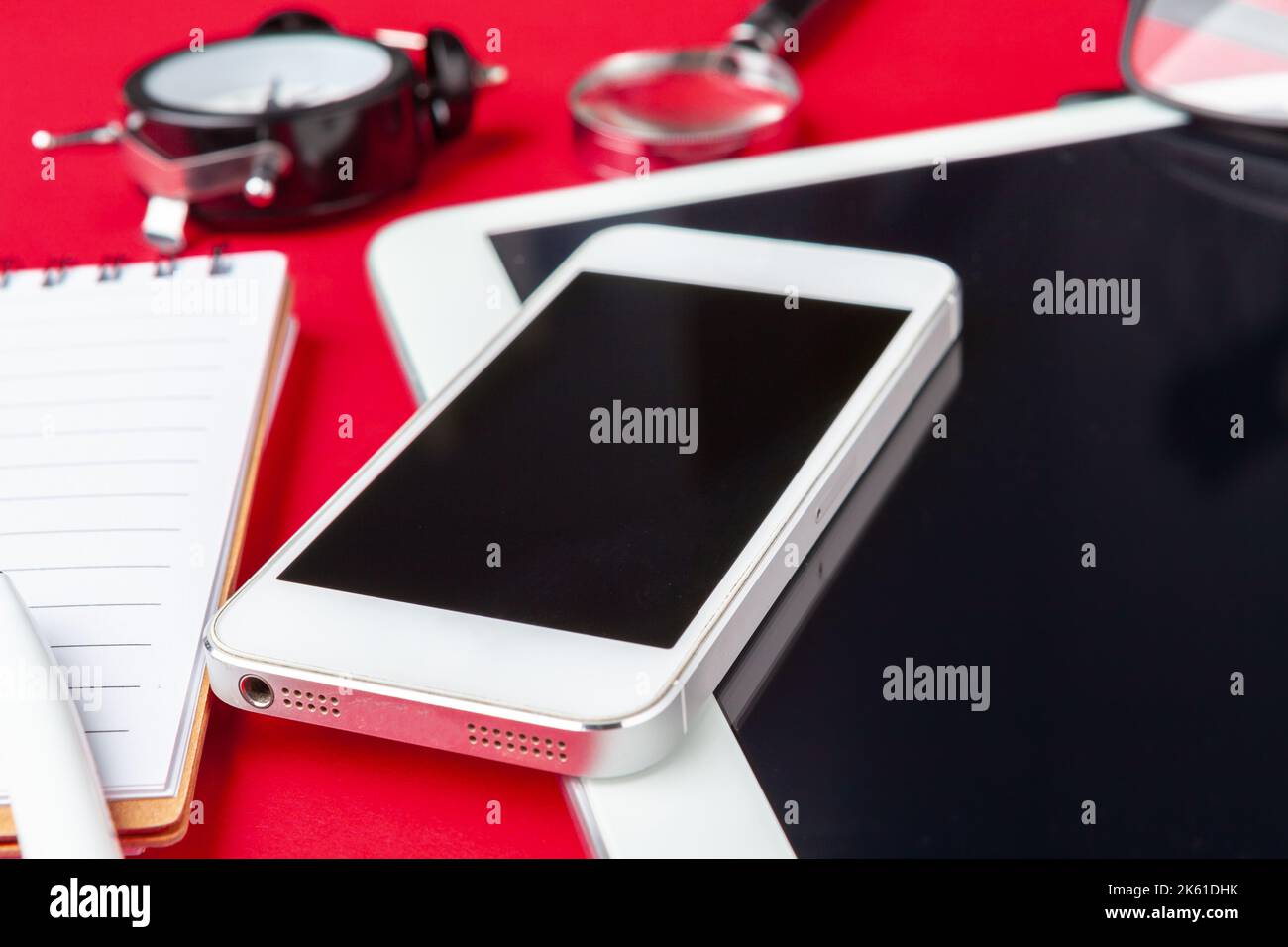 Red office desk table with blank notebook, keyboard and supplies. Top