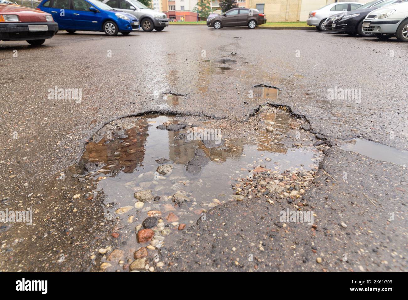 Water filled pot hole in the road. Copy space area for construction