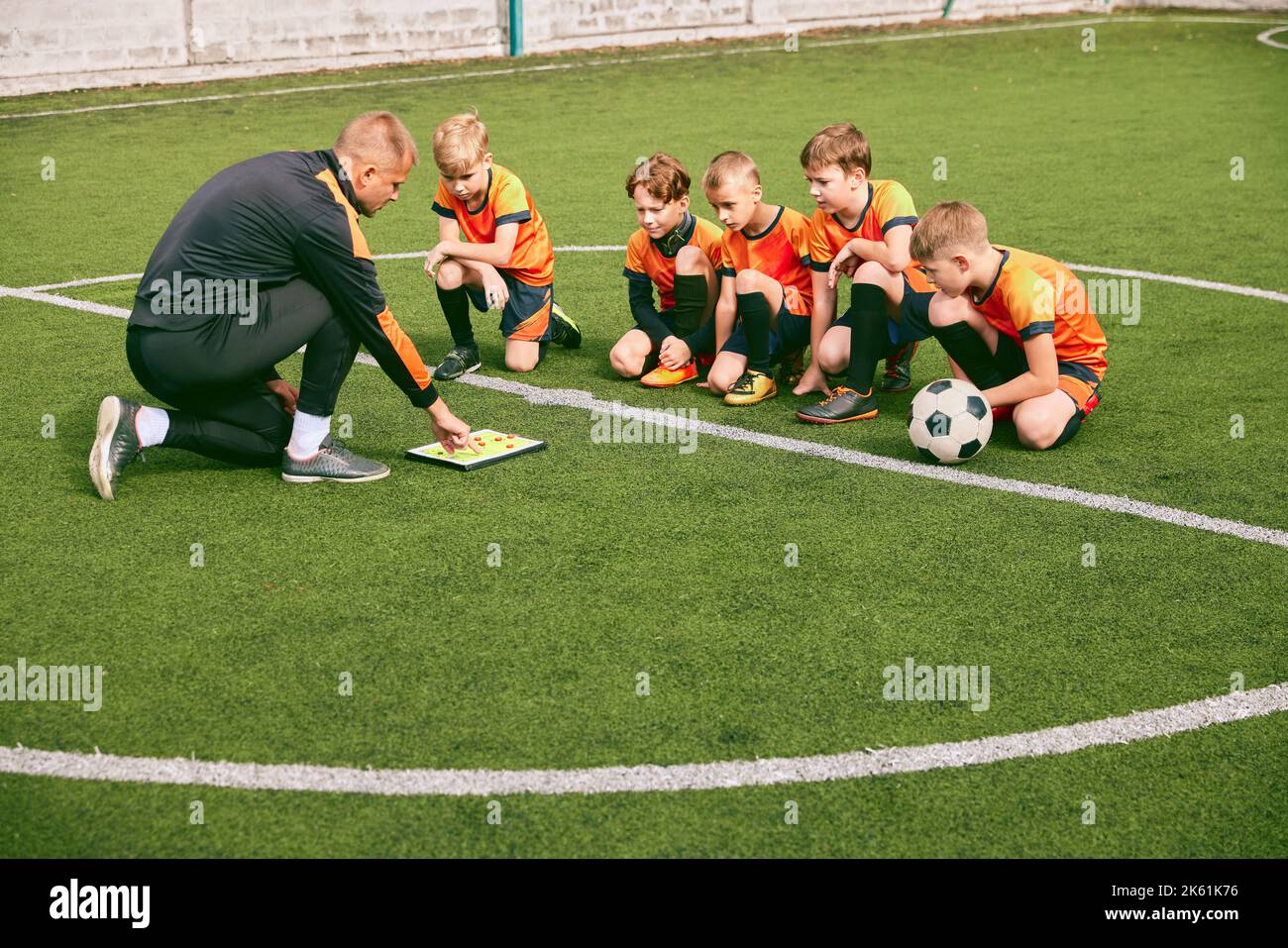 Football training. Soccer coach explaining game rules and strategy