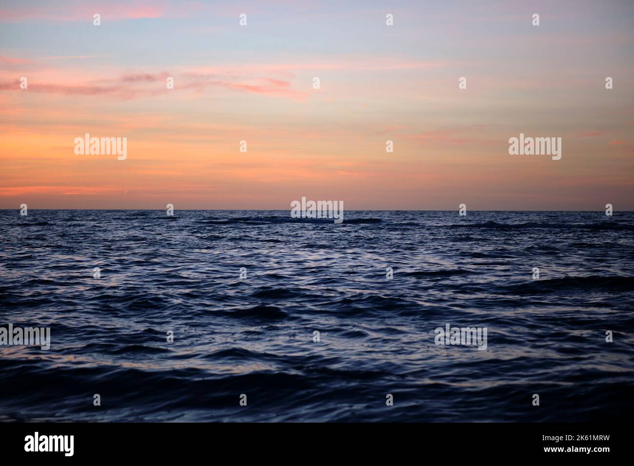 Dramatic red ocean waves at sunset with soft evening sea dark water Stock Photo