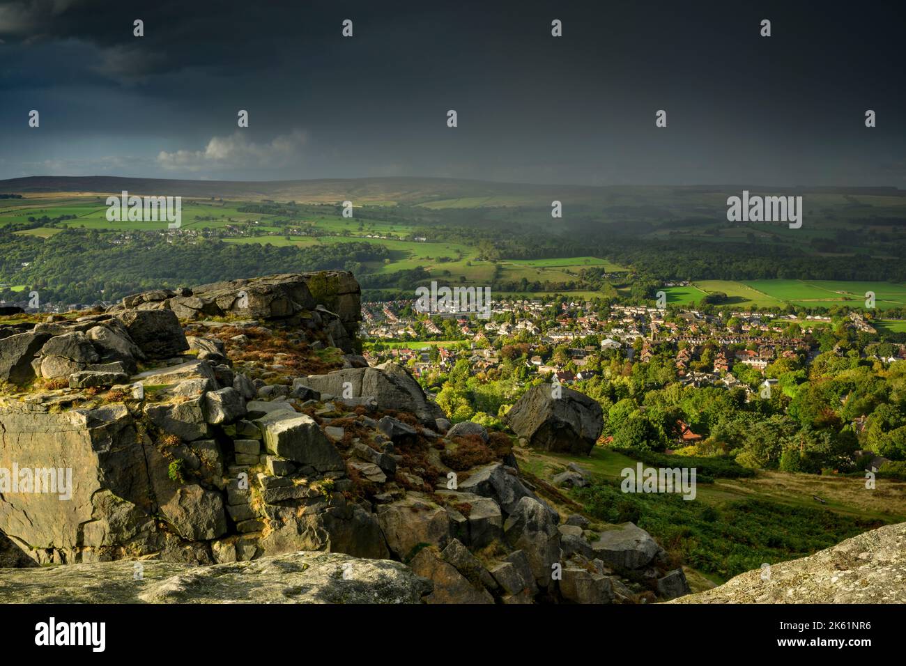 Cow & Calf Rocks overlooking scenic atmospheric rural landscape (high moorland hill crag, sun & raining) - Ilkley Moor, West Yorkshire, England, UK. Stock Photo