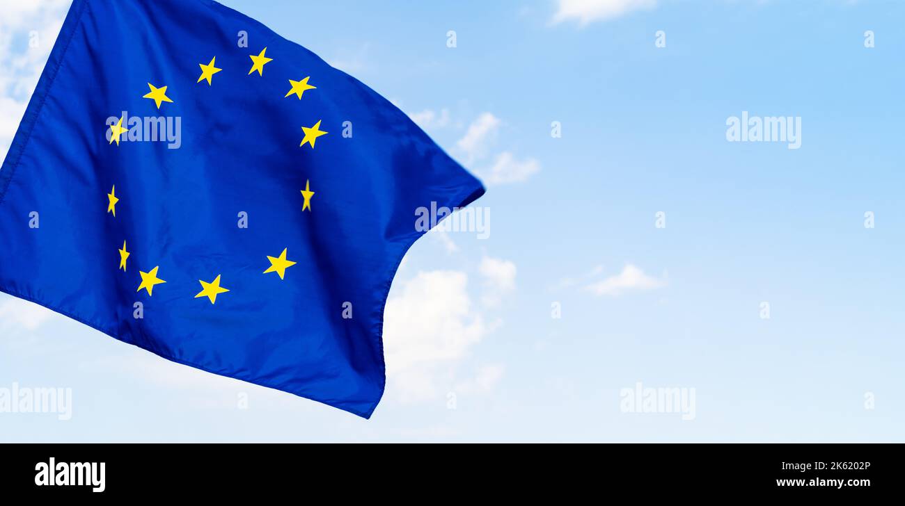 European Union flag against blue sky waving Stock Photo - Alamy