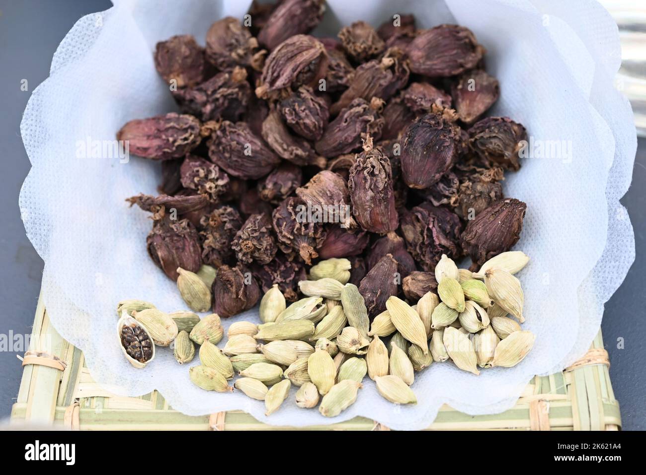 dried cardamom seeds on a bamboo plate. Stock Photo