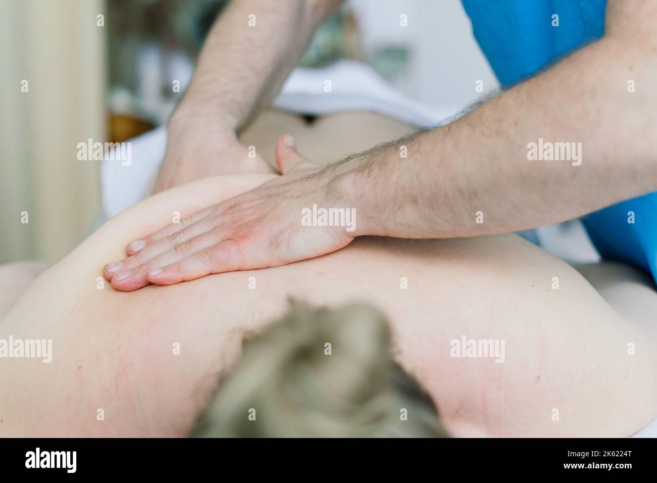 Young fat woman getting massage treatment in day spa cabinet. Stock Photo