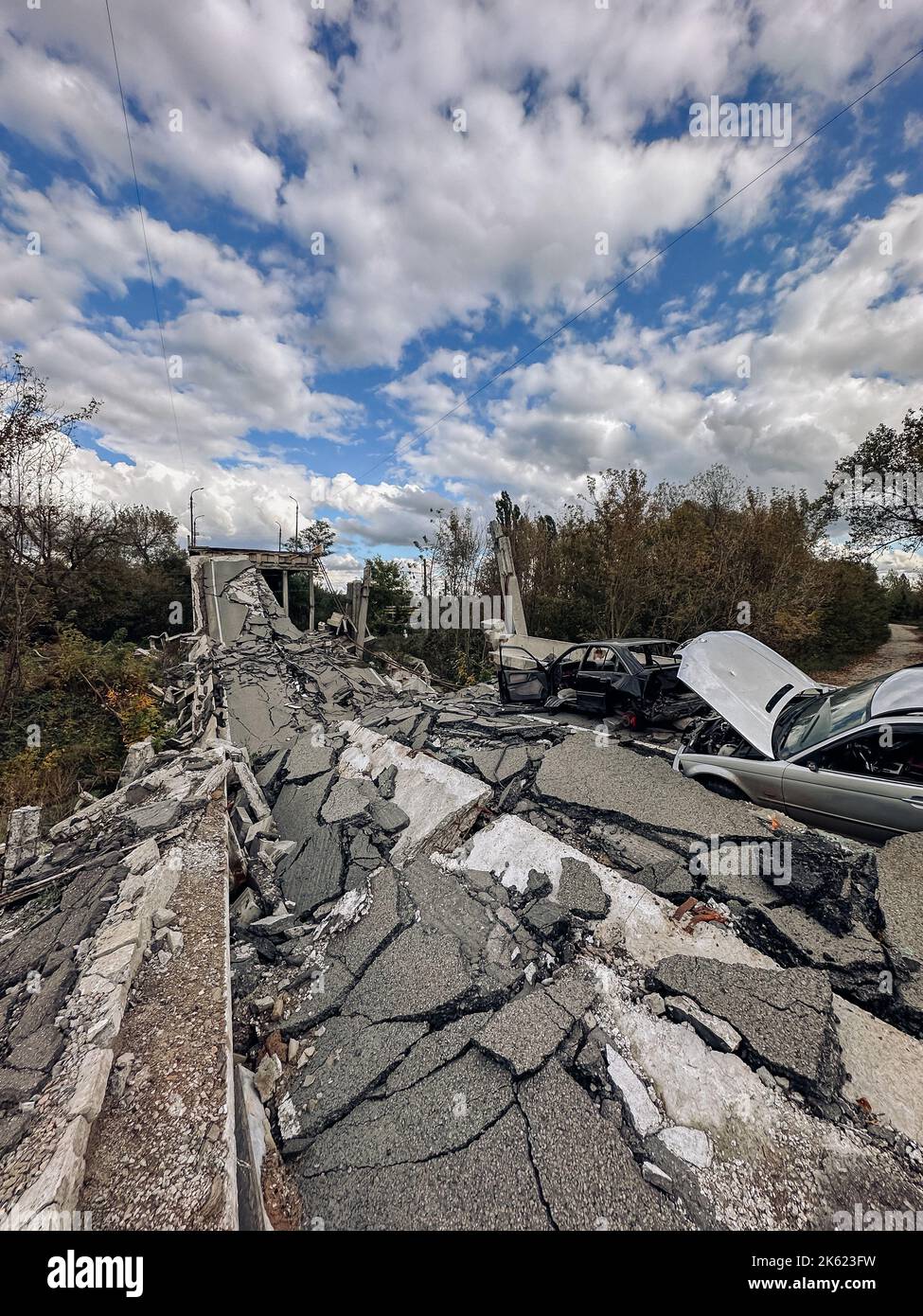 Destroyed bridge and burnt cars in liberated from occupation Kupiansk town in Kharkiv region in